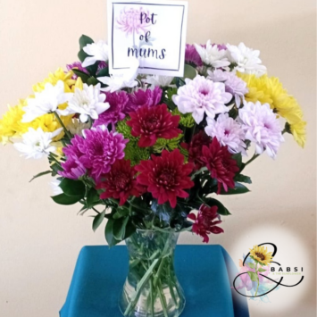 A vibrant bouquet of colorful sprays in a glass vase.